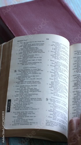 Hand turning pages of the Holy Bible. Reading scripture concept. Vertical video.