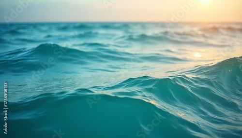 Fototapeta Naklejka Na Ścianę i Meble -  Teal Blue Ocean Waves Flowing Gently Under a Warm Golden Sky