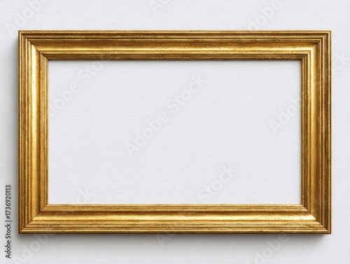 A rectangular, ornate gold frame casts a shadow on a textured, white surface