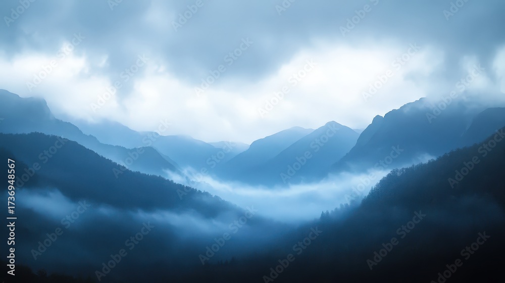 Obraz premium A misty mountain range under an atmospheric sky, conveying vastness and mystery.