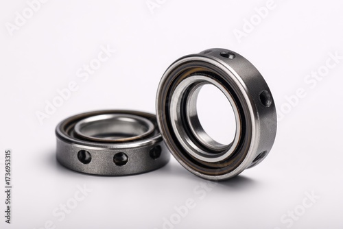 Two metallic rings, likely bearings,  close-up on white background.  Precisely crafted, with  multiple small holes