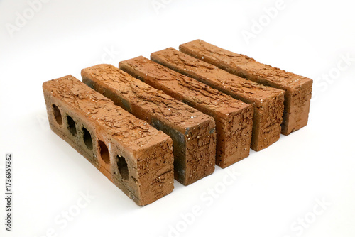 Row of rough clay bricks showing texture on white backgroundRow of rough clay bricks showing texture on white background