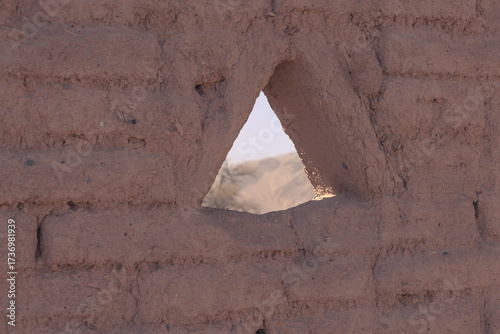 Triangular opening in a textured adobe wall frames