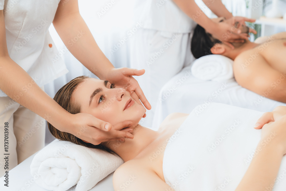 Obraz premium Caucasian couple enjoying relaxing anti-stress head massage and pampering facial beauty skin recreation leisure in dayspa modern light ambient at luxury resort or hotel spa salon. Quiescent