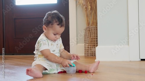 Infant Sitting Indoors with Messy Raspberries and Wooden Door Background