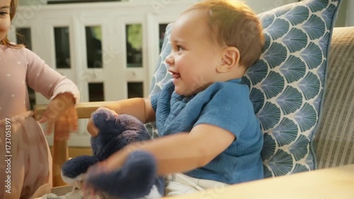 Toddler Handing Gift to Baby Sitting on Chair
