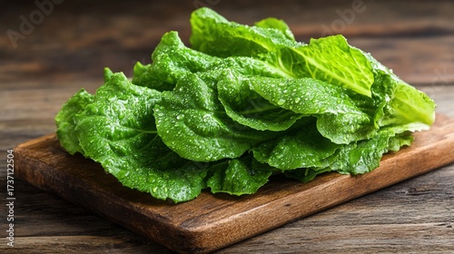 Fresh, vibrant green lettuce leaves on a wooden cutting board.  Crisp, healthy, and ready to eat
