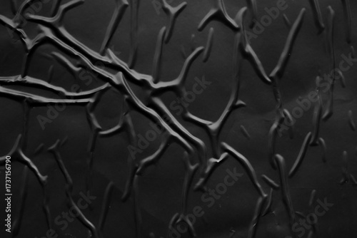 black crumpled and creased plastic poster texture background