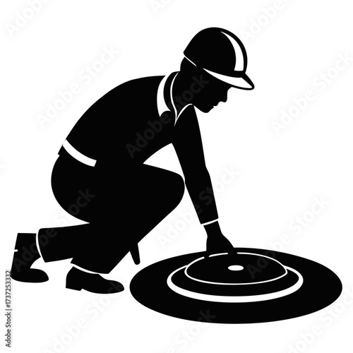 Worker in hard hat inspecting manhole cover silhouette