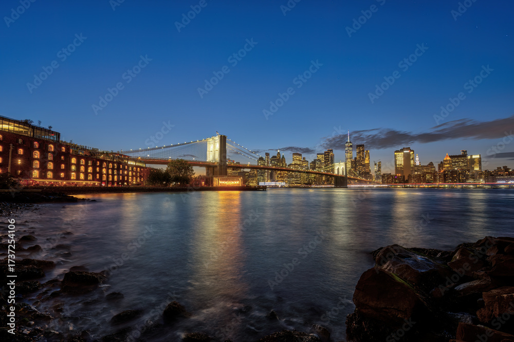 Obraz premium The famous Brooklyn Bridge and the skyline of Manhattan in New York City at dusk