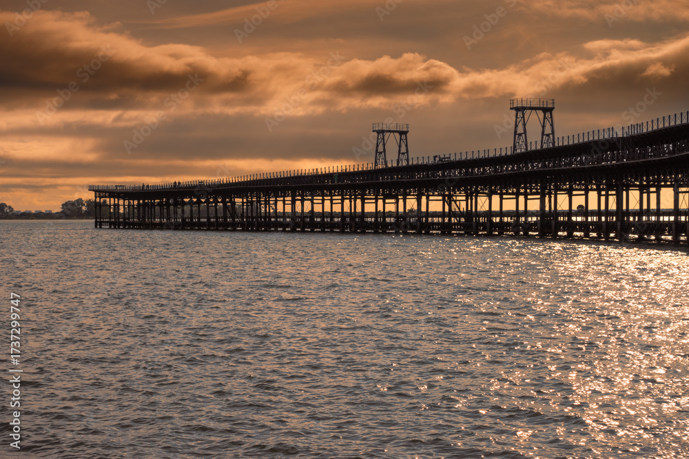 Fototapeta premium Pier of the Rio Tinto Company at sunset (Huelva, Spain). Rio Tinto mineral loading pier declared an Asset of Cultural Interest. Pier at sea.