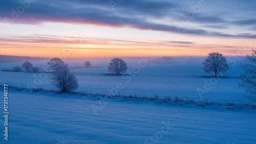 Snowy winter field at colorful sunset horizon