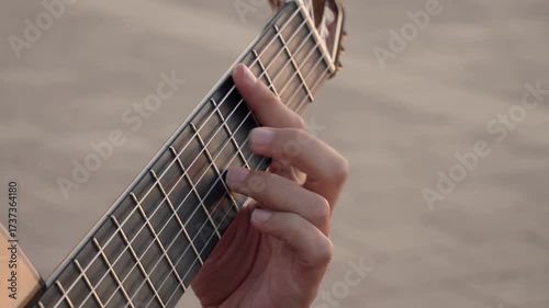 Close up of a man's hand playing chords on the fretboard of a classical guitar. Musician practicing traditional spanish flamenco music