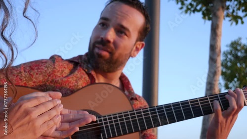 Professional musician playing flamenco guitar outdoors. Close up of a woman's hands clapping along to the traditional spanish music