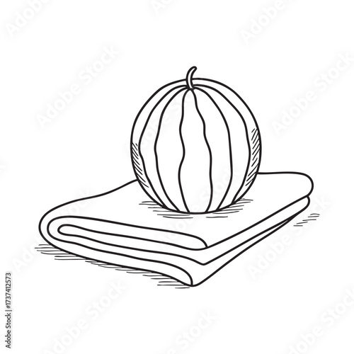 A whole watermelon placed on a towel laid on the ground