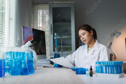 Fotografie Woman scientist analyzing scientific research documents in laboratory