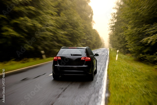 Ein Auto fährt schnell auf einer Straße im Herbst