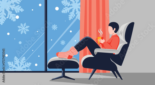 Person relaxing in armchair by window with snowflakes falling outside.
