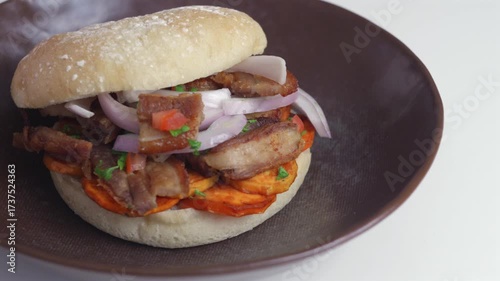 Shot focusing on bread with chicharron made with pieces of pork and vegetables.