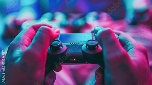 Close-up of hands gripping a game console controller in a vibrant gaming setup with pink and purple lighting. Ideal for tech, lifestyle, or gaming visuals.