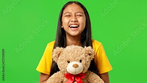 Happy Young Asian Girl Holding a Teddy Bear on Green Screen.