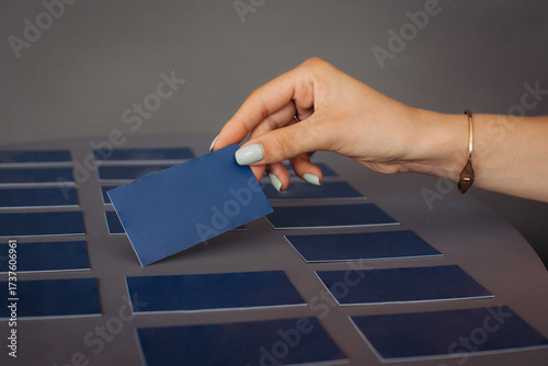 Hand picking blank blue business card from grid
