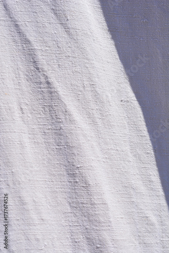 The textured surface of a linen sheet, highlighting the folds and wrinkles with a deep shadow