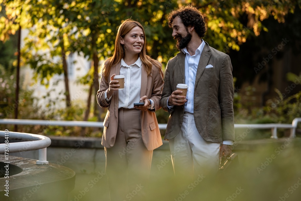 Fototapeta premium Business people walking and talking during coffee break outdoors