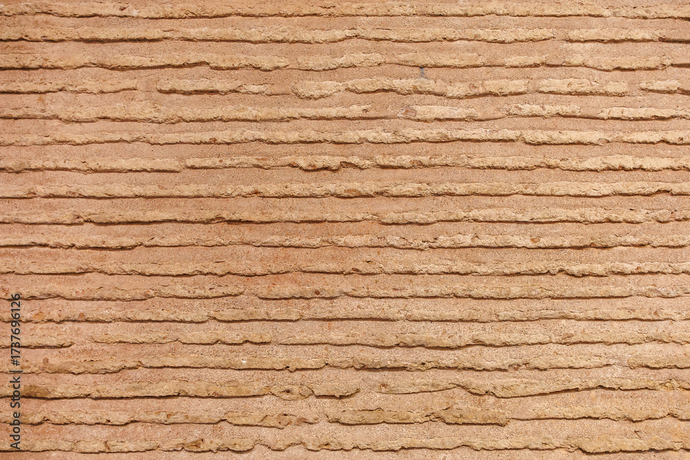 Obraz premium Textured brown earthen wall with horizontal lines pattern