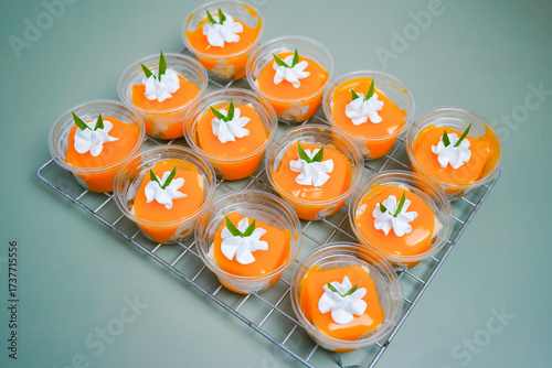 Orange ball cake placed on a grid on a green background.