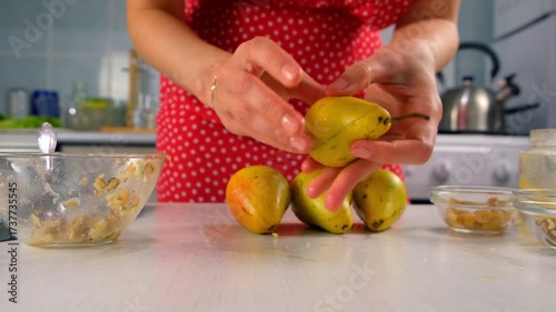 Pastry chef connects halves pears with nuts filling cooking dessert on kitchen. Creating delicious healthy food. Cuisine culinary prepare homemade cook dish domestic healthy meal recipe ingredients.