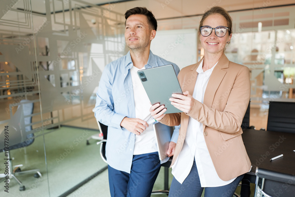 Obraz premium Professionals collaborating in a modern office setting with digital tablet