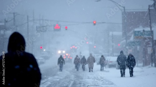 People walking on snowy city street during heavy snowfall in cold winter weather.