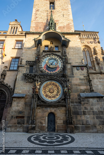 Stunning sunrise over Prague with warm golden light illuminating historic architecture, cobblestone streets, and iconic city landmarks in high-quality detail.