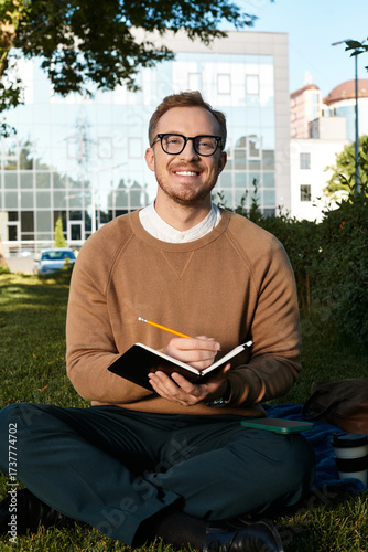 Wallpaper Mural Young university teacher enjoying a sunny day while taking notes outside on campus Torontodigital.ca