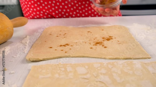 Pastry chef woman sprinkling cinnamon on fresh dough on kitchen cooking dessert. Create delicious healthy food pastry. Cuisine culinary prepare homemade cook domestic meal baking recipe ingredients.