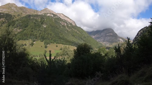 Mountain range with a cloudy sky. The clouds are white and fluffy. The mountains are covered in trees
