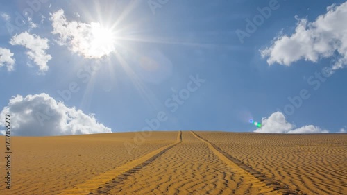  wide sandy desert with car track under a sparkle sun time lapse scene
