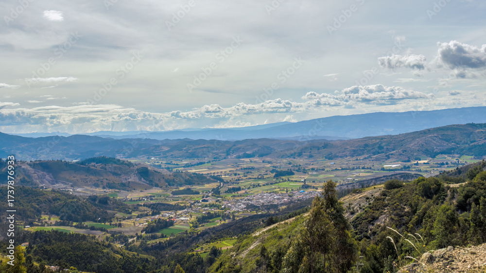 Naklejka premium View of the valley and the town of Cucaita, and the farm lands surrounding it, from a mountain on the south, in the eastern Andes of central Colombia.