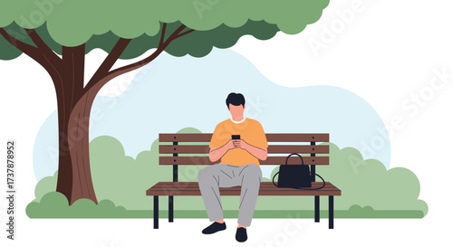 A man sits alone on a park bench using his phone and a bag sits next to him.