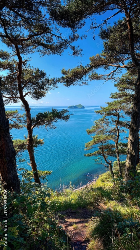 Obraz premium Coastal vista with trees framing ocean, island, and blue sky