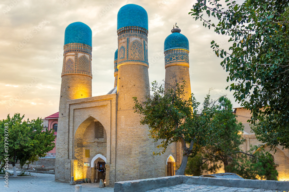 Fototapeta premium View on Chor Minor madrasah at early dusk in Bukhara, Uzbekistan. Chor Minor or Madrasah of Khalif Niyaz-kul in historic city. Architectural historic monument with turquoise domes. Built in 1807