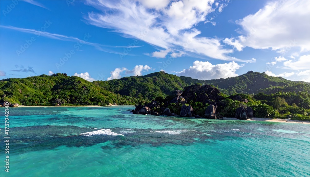 Fototapeta premium Verdant island scenery unfolds under a bright blue sky filled with fluffy white clouds, showcasing vibrant turquoise waters gently lapping against a sandy shore, complemented by lush green mountains.