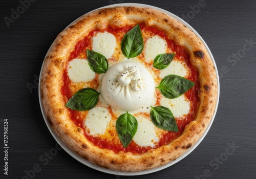 Delicious pizza topped with fresh basil and creamy burrata cheese on a plate.