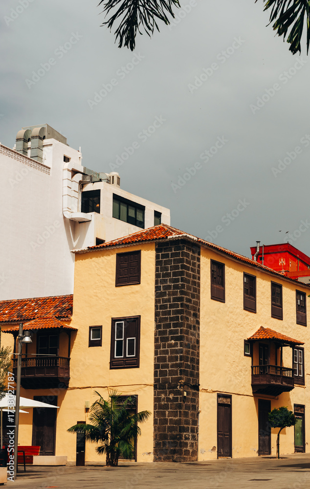 Fototapeta premium Urban yellow house with brown trim.