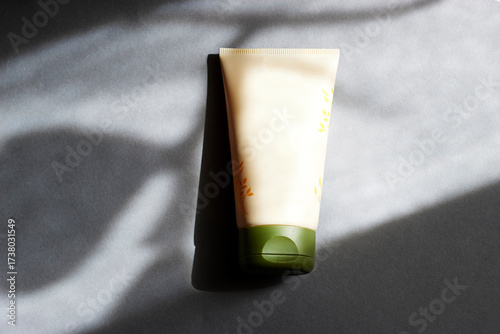 Cream Tube On Gray Surface With Green Cap: Natural Light And Soft Shadows