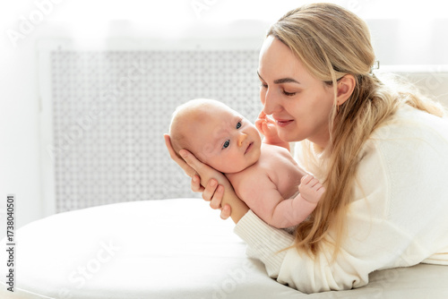a mom with a baby, a mother holding a small newborn baby in her arms, kissing and gently hugging, happy motherhood, a family with a small child
