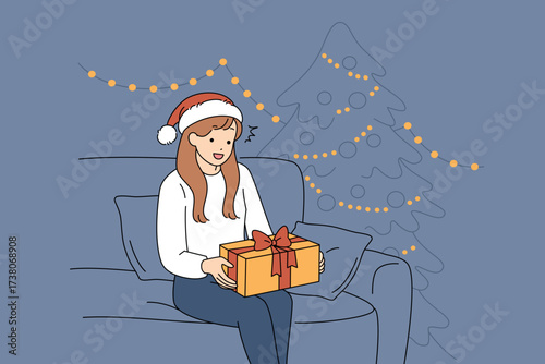 A joyful woman by a beautifully decorated tree during a delightful Christmas gift exchange
