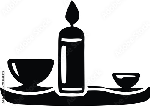 A lit candle with two small bowls on a decorative tray a symbol of light warmth and ritual or offering preparation