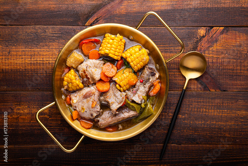 Chilean cuisine of Latin America. Traditional Chilean cazuela de cerdo. Pork soup with potatoes and corn, stew with corn and carrots on dark wooden background top view